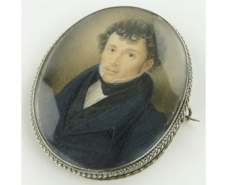 An early 19th century miniature watercolour portrait of a gentleman,
unsigned, in unmarked silver brooch mount with hair pane