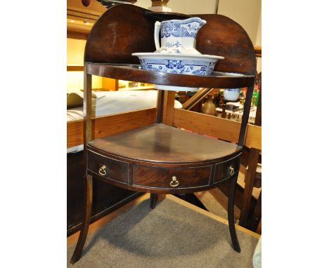 A Georgian mahogany corner wash stand,
complete with blue and white wash basin, height 3'5".