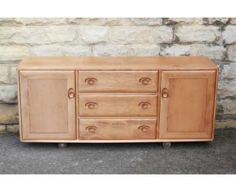 A Light Oak Ercol Sideboard, central drawers with fitted interior and cupboards to either side, approx 155 l x 33 d x 70 h cm