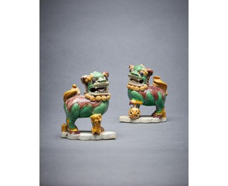A pair of Chinese glazed biscuit Buddhist lion joss-stick holders, Kangxi, glazed in shades of ochre, green and aubergine and
