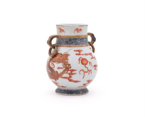 A Chinese iron-red twin handled vase, zun, Republic, the globular mid-section below a waisted neck and supported by a high, s
