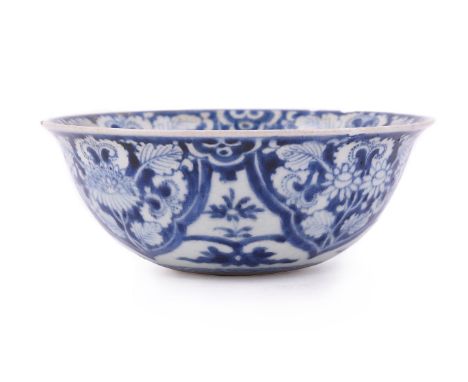 A Chinese blue and white soft-paste 'flower' bowl, Kangxi, painted with flowers and foliage to in interior and exterior and t
