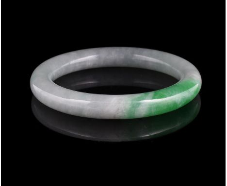 A Chinese green jadeite bangle, 19th or 20th century, with apple green jade inclusion, 8cm diameter and inner ring approximat