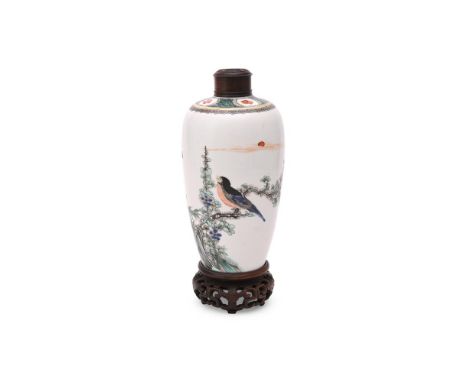 A Chinese famille verte vase, Kangxi, brightly enamelled with a gnarled flowering prunus branch issuing from rockwork and per