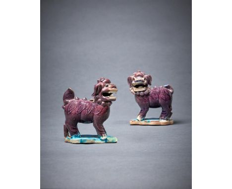 A pair of Chinese figures of Buddhist lions, Kangxi, with aubergine glaze and turquoise leaf-shaped bases, with Rothschild co