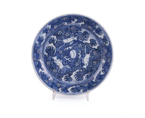 A Chinese blue and white 'Galloping Horses' dish, early Kangxi, finely painted in cobalt vivid blue tones with a galloping ho