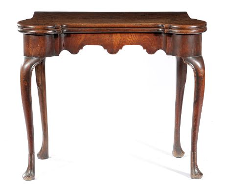 A GEORGE II IRISH MAHOGANY CARD TABLE C.1740 the inverted breakfront fold-over top on a single gate support, revealing a baiz