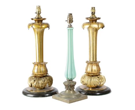 A PAIR OF WILLIAM IV GILT BRASS TABLE LAMPS C.1835 of lappet form, with a leaf scroll base and a later ebonised wood foot, to