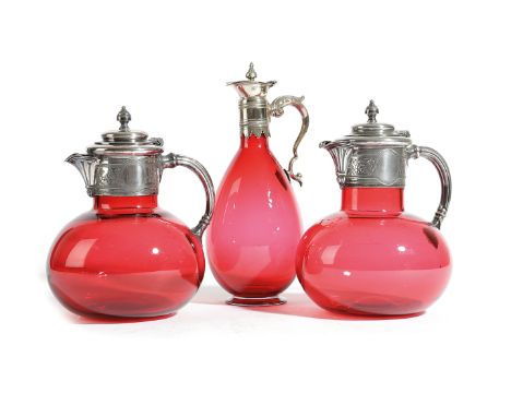 A PAIR OF RUBY GLASS AND SILVER PLATED CLARET JUGS LATE 19TH CENTURY together with a similar example with a pear shape body (