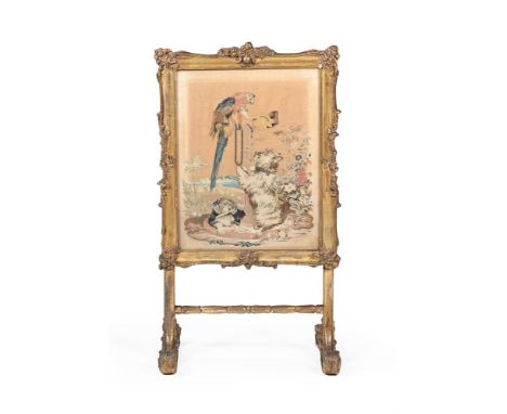 A VICTORIAN GILTWOOD FIRE SCREEN MID 19TH CENTURY The needlework panel with a parrot, birds and terrier and spaniel 118cm hig
