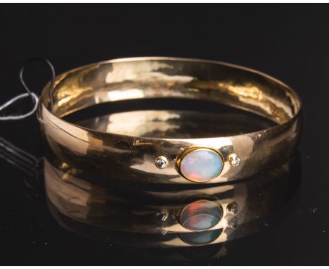 Armreif 585 GG, besetzt m. 1 Opal-Cabochon u. 2 kl. Diamanten im Brillantschliff,gestempelt: Handarbeit / 585, Dm. innen ca. 