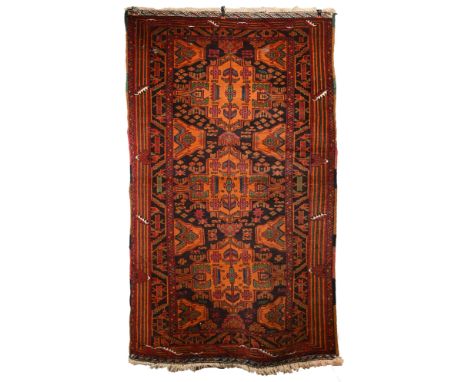 AN AFGHAN CAMEL WOOL RUG, 20TH CENTURY. With geometric roundels enclosing foliate motifs predominately in burnt orange, green