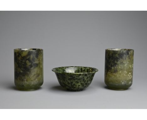 THREE CHINESE SPINACH JADE CUPS AND BOWL, 20TH CENTURY. Dark green and black mottled jade carved into cups and small bowl. Cu