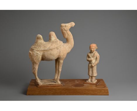 A CHINESE POTTERY MODEL OF A BACTRIAN CAMEL AND ATTENDANT, TANG DYNASTY. Each standing and mounted on a later fitted wooden d