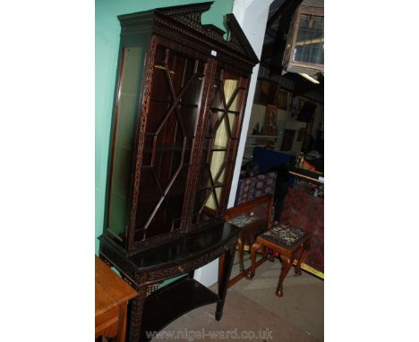 A reproduction Chippendale revival Cabinet on Stand having pierced, fretcut pediment over opposing pair of glazed doors, the 