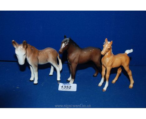 A Royal Doulton Bay Foal, a Beswick gloss Palomino Foal and a Sylvac Donkey