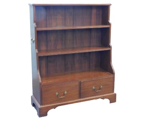 A mahogany waterfall bookcase in George III style, with tapering reeded end supports and shelves, the base with two frieze dr