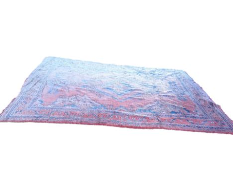 A large Turkish carpet, with a geometric design on a typical red ground with multiple borders, 280cm x 370cm.