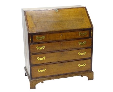 An early 19thC oak bureau, the fall enclosing a fitted interior with a well, the front with a false drawer above an arrangeme