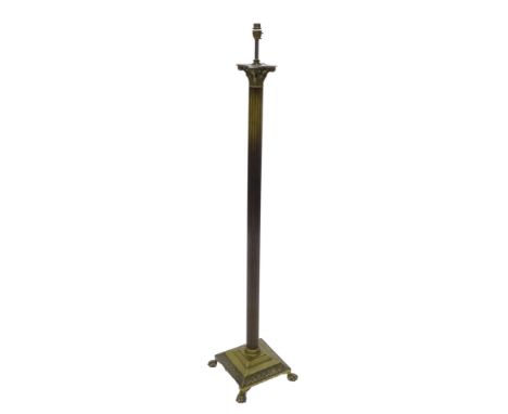 An early 20thC brass Corinthian column standard lamp, with paw feet and a tasselled shade.