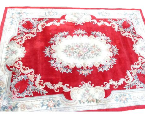 A large Chinese wool cut carpet, decorated with flowers leaves and scrolls, on a red ground, 365cm x 278cm. (AF) 