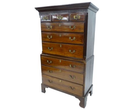 An early 19thC mahogany chest on chest, the top with a dental cornice and a blind fret carved frieze above an arrangement of 