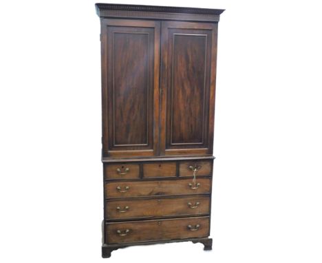 A mahogany clothes press, the top with a moulded cornice, above two panelled doors, enclosing shelves, the associated George 