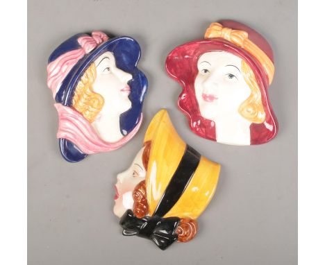 A Cope &amp; Co Art Deco ceramic wall plaque of a lady in a bonnet along with two similar examples. The Cope &amp; Co example