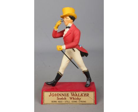 A vintage Johnnie Walker Scotch Whiskey advertising figure. Approx. height 21cm.  Crack to plaque.