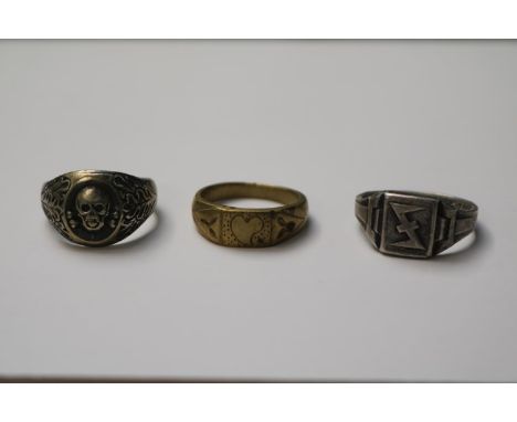 A 1943 dated ring possibly military, a Skull ring and a yellow metal trench art example 