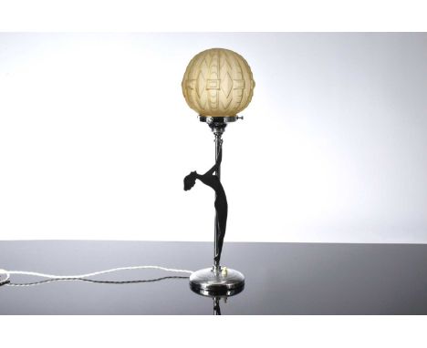 An Art Deco chromed table lamp, circular base with support having revolving silhouette figure of a lady and supporting a fros