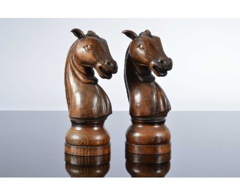A pair of second half 20th century carved wooden novelty salt and pepper grinders, 21cm high, modelled as knight chess pieces