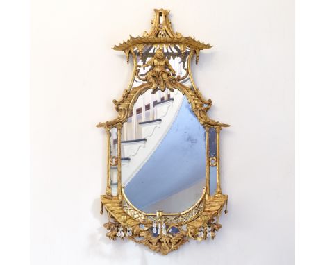 The shaped mirror plate within an architectural and mirrored border surmounted by a pierced pagoda crest with quatrefoil trel