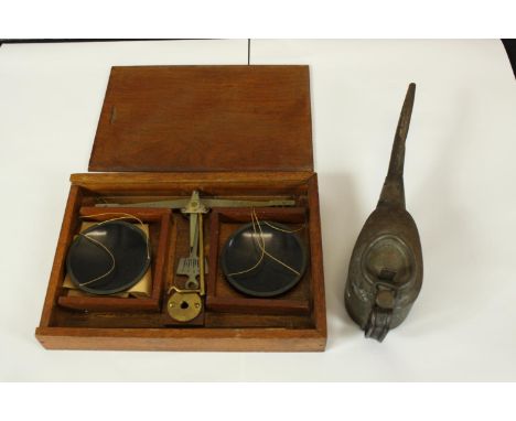 A cased set of scales and a small oil can. The largest measures H.23 x W.17 cm. 
