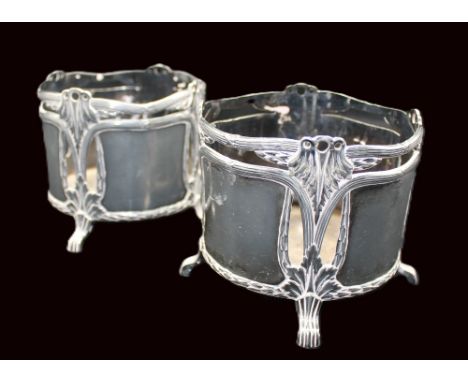 A pair of WMF silvered bottle coasters, each of cylindrical shape with four tapered feet with ribbed design, side pierced to 
