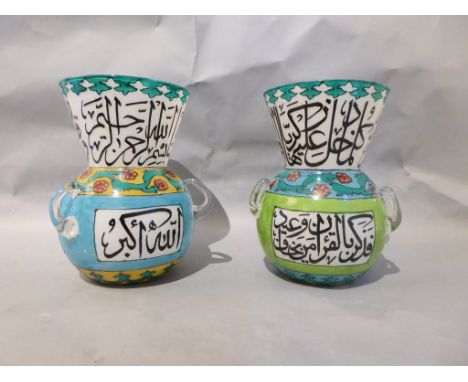 A pair of coloured, glass C16th style Mosque lantern vases, the bulbous base below flared rim with central panelled script wi