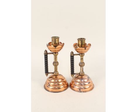 A pair of Arts and Crafts copper and brass candlesticks with bobbin turned ebonised side handles, Rd No.53791, 7 1/2" high