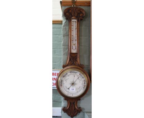 A carved oak aneroid barometer