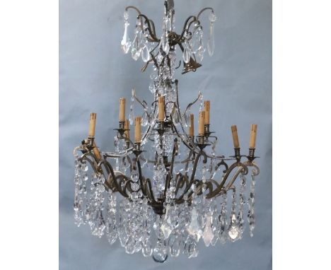 An Italian bronze and cut glass twelve light chandelier, hung with flower and lappet and tear shaped drops, overall drop 4ft 