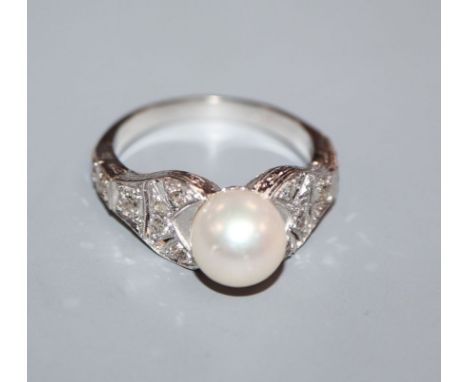 A modern 750 white metal, cultured pearl and diamond set dress ring, with pierced shoulders, size R/S.