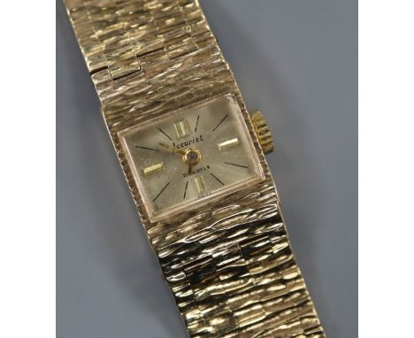 A lady's 1960's textured 9ct gold Accurist manual wind wrist watch, with spare link.