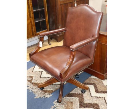 A reproduction brown leather desk chair