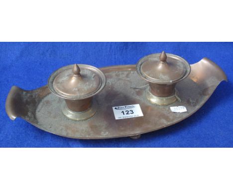Lacquered copper Arts and Crafts boat shaped double inkwell, the wells with ceramic liners and finialled covers, marked: W.A.