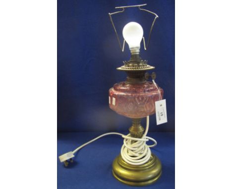 Early 20th Century oil burner with cranberry glass reservoir on a brass circular base, now converted to a table lamp.(B.P. 24