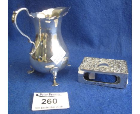 A silver match box holder and a small silver cream jug. (B.P. 24% incl. VAT)