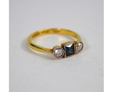 An antique sapphire and diamond three stone ring, the central rectangular cut blue sapphire with two circular old brilliant c