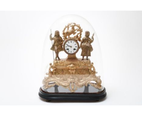 Zamak mantel clock, gold-coloured with 2 figures and Lamb of god,  at black wooden base under a glass dome, France late 19th.