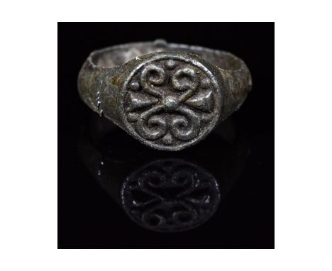 Ca.800-1200 AD. Interesting wearable Medieval pewter ring with circular-shaped bezel with a high relief of possibly stylised 