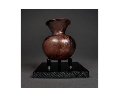 ca.200-300 AD. An amazing aubergine glass flask with globular body and funicular neck, dimpled base; the glass delicate and s