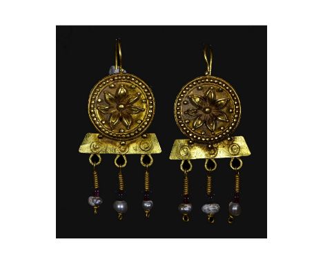 Ca.100 AD. A matched pair of gold earrings, each a domed plaque with beaded wire border, filigree bands, central floral relie